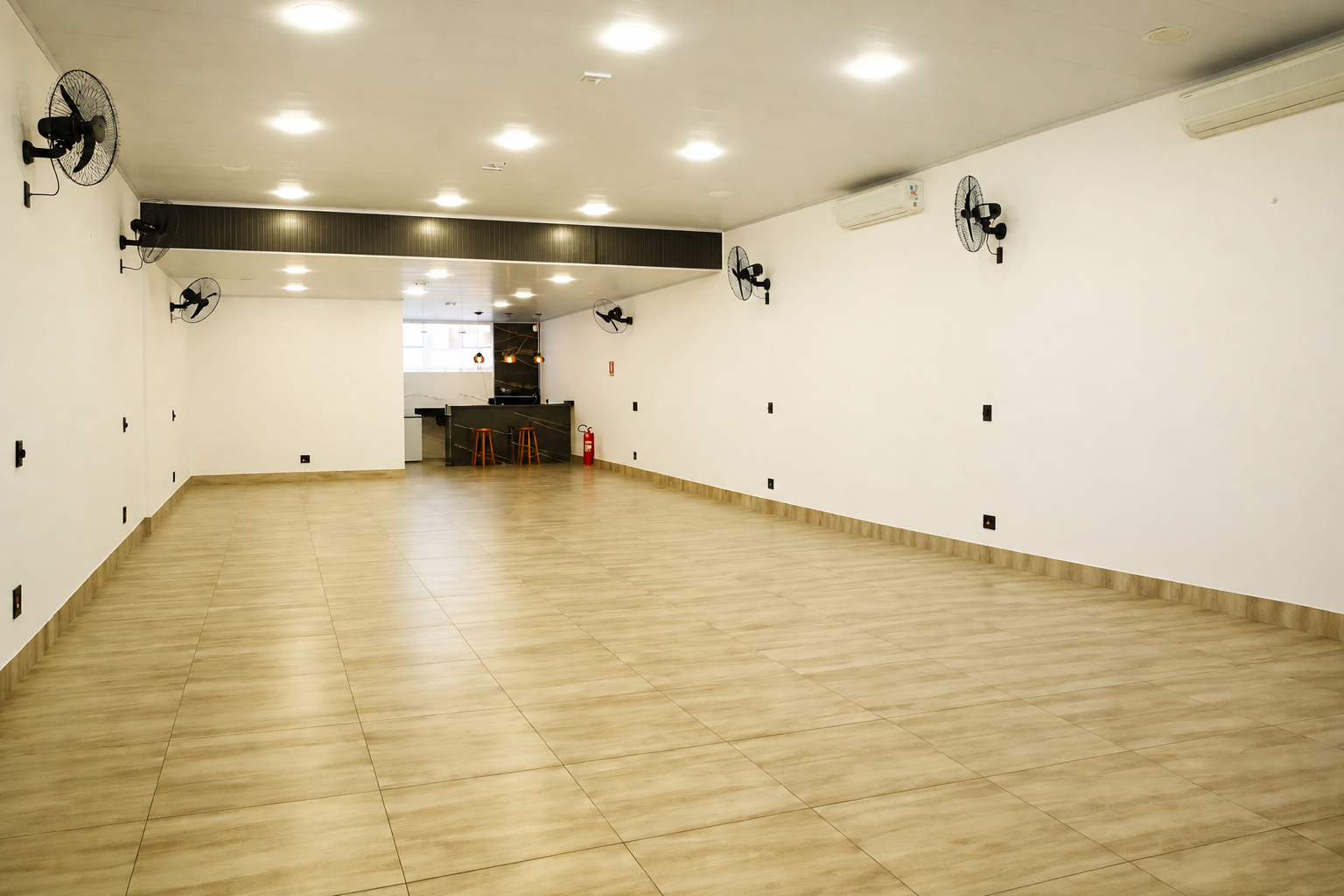 Interior do salão de eventos com iluminação suave e pé-direito alto